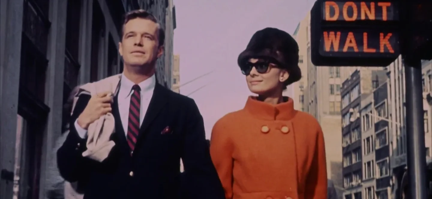 Audrey Hepburn as Holly Golightly and George Peppard as Paul Varjak walking together through New York in a Breakfast at Tiffany’s trailer frame