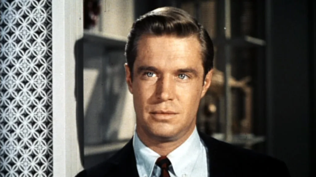George Peppard as Paul Varjak looking toward the camera in a Breakfast at Tiffany’s trailer frame